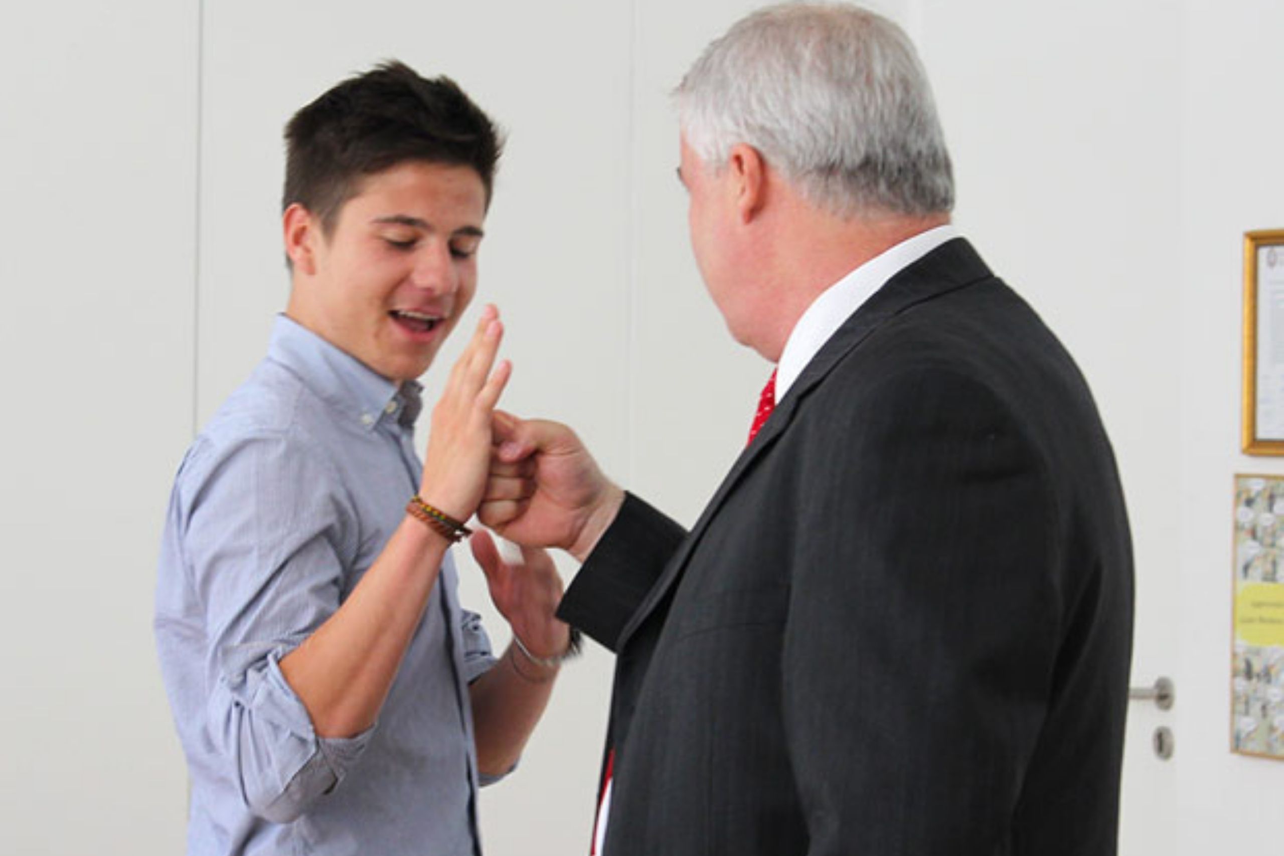 A student taking place in a youth business and entrepreneurship program fist bumps with a mentor.
