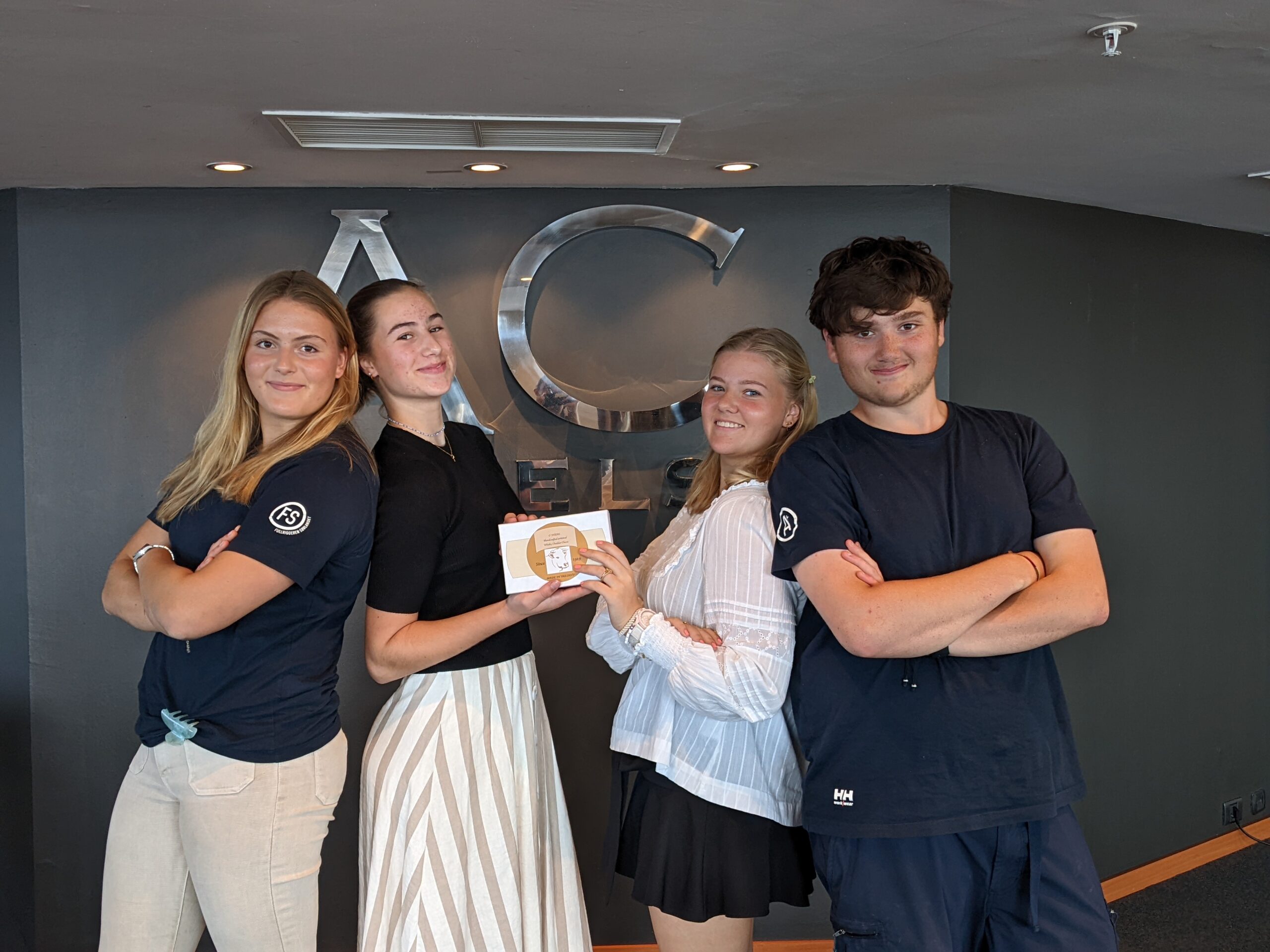 Four students show off their project and hold the final packaging for their product during a business workshop for teenagers (The Golden Ticket Workshop).